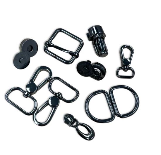 A set of black metal hardware accessories, including buckles, swivel snaps, carabiners, and rings, arranged on a plain white background.