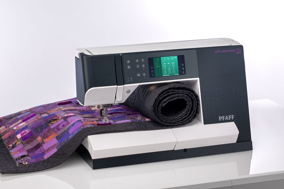 Quilting sewing machine with large throat space stitching a rolled quilt