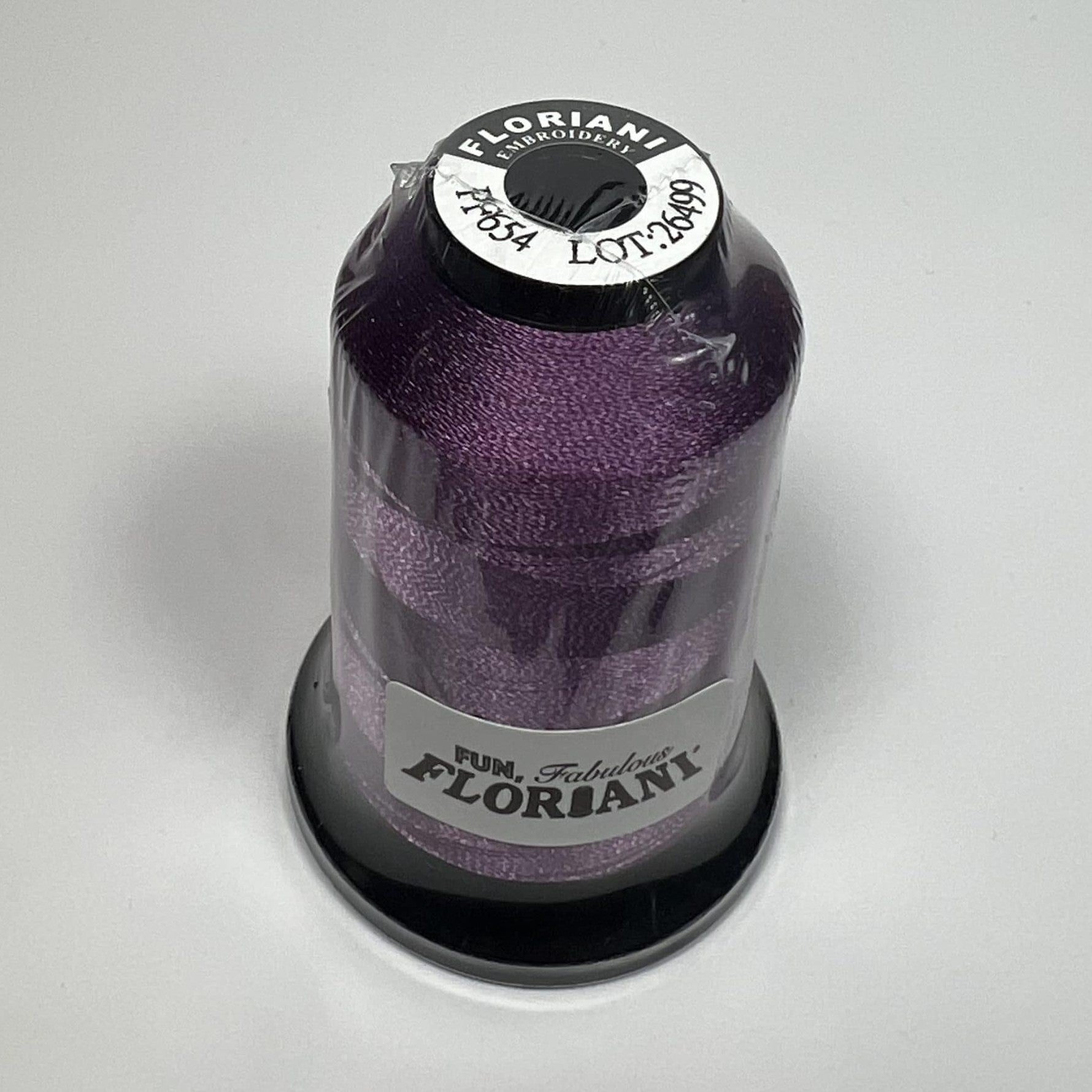 A spool of Floriani embroidery thread in orchid color, placed against a white background.