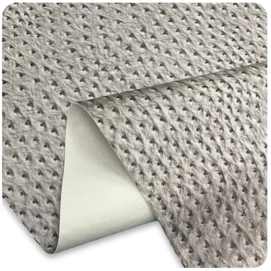 A close-up of a textured gray non-slip vinyl sheet with a raised ostrich faux leather pattern, shown partially rolled over to reveal a smooth white backing.